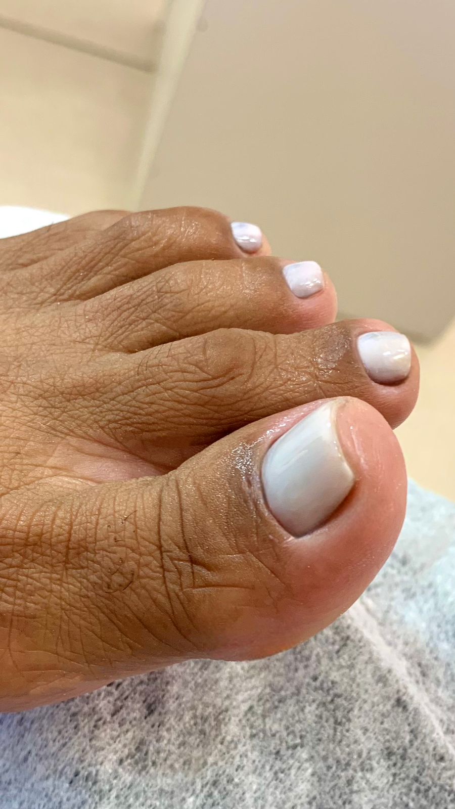 Unhas dos pés em tom cinza claro